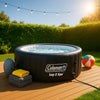 Premium inflatable hot tub on wooden deck with sunny towel, beach ball, and bright blue sky at golden hour