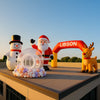 Sunlit rooftop with colorful holiday promo inflatables secured on a modern commercial building, blue sky background